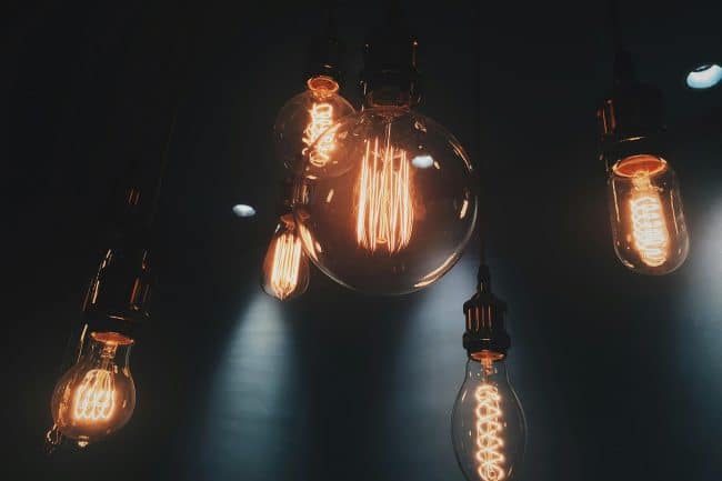 Store flotte glødepærer hænger i mørkt rum med spotslights på væggen hos marketing freelancer, freelance marketingkonsulent og freelance marketing konsulent i Randers Marketingsnedkeren